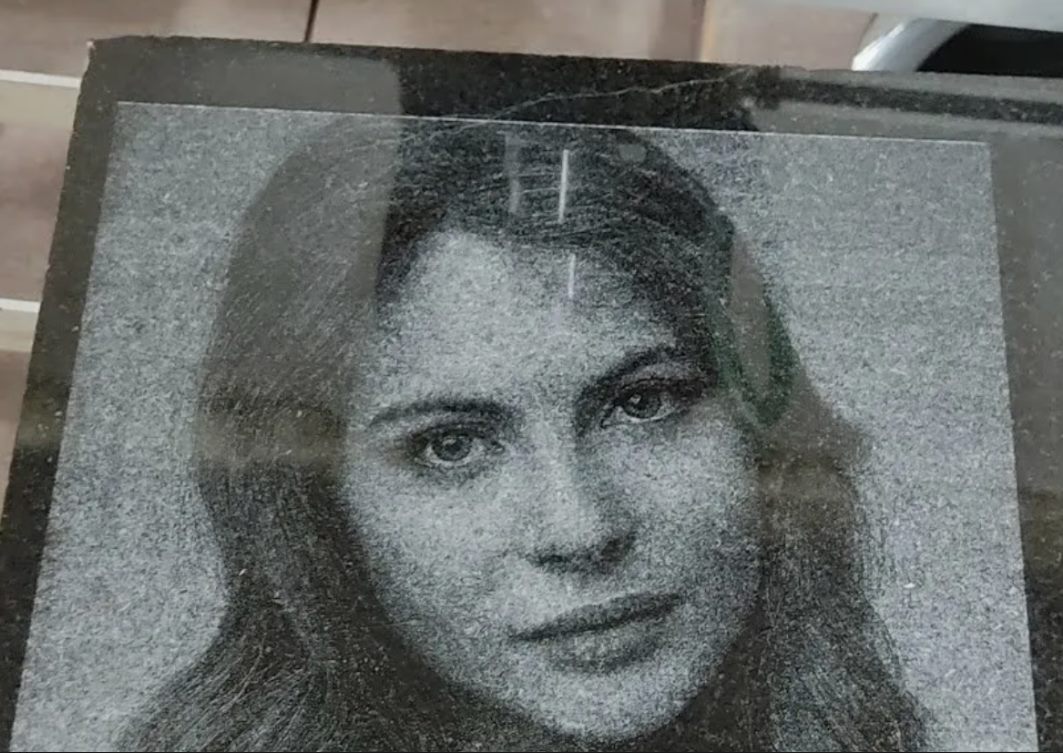 Пример лазерной гравировки портрета на черном граните с заметной зернистостью камня